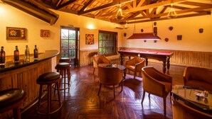 A bar area with wooden furniture, a pool table, and a billiards table. - Gateway Chikmagalur (Chikkamagaluru)