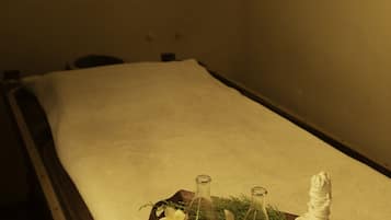 Experience ultimate relaxation in this serene spa setting, featuring a massage table, essential oils, and soothing ambiance.