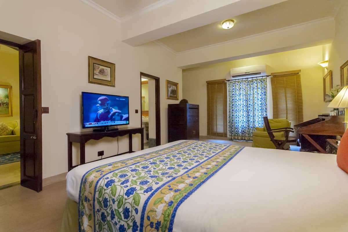 Une chambre d’hôtel avec un lit, une télévision, un bureau et une chaise.