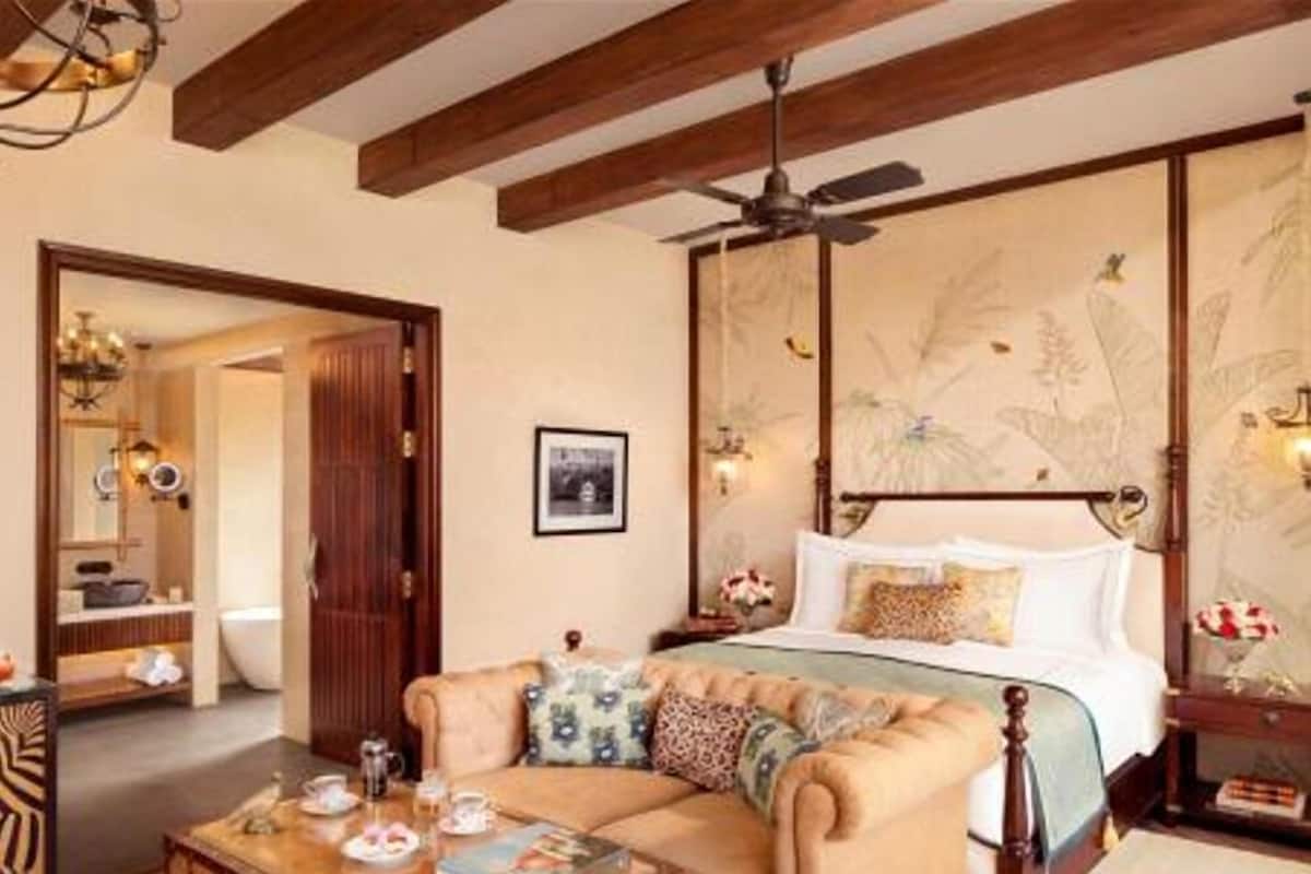 Une chambre à coucher avec un lit, un plafond en bois, un ventilateur de plafond, une table de chevet, un miroir et une fenêtre.