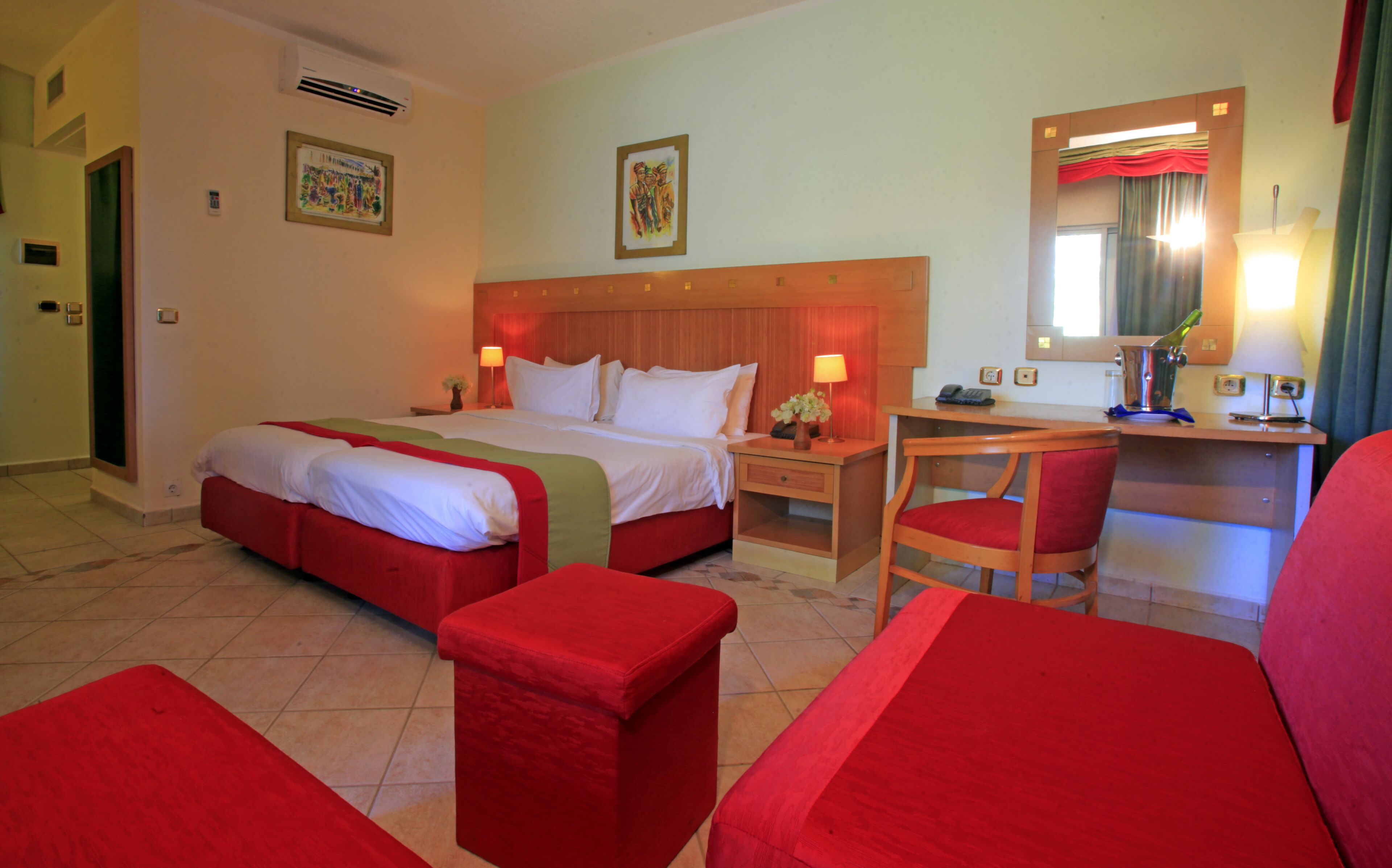 Habitación de hotel con una cama grande, un escritorio, una silla y una mesita.