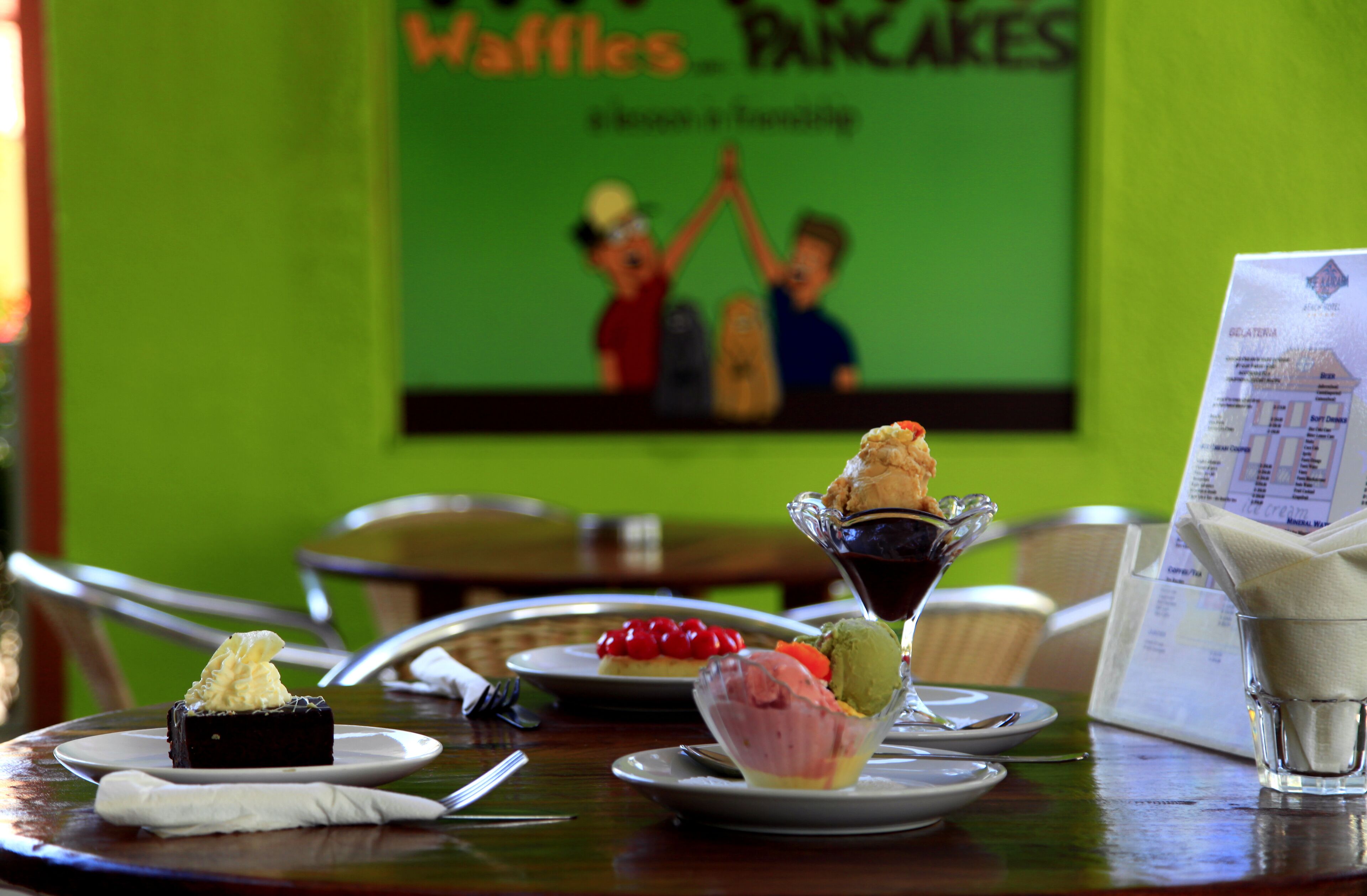 A dining table with various desserts and a menu.