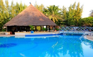 Una piscina al aire libre, sillones reclinables de piscina
