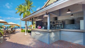 An outdoor bar area with a counter, umbrellas, and seating. - Pineapple Beach Club Antigua - Adults Only – All Inclusive (Willikies)
