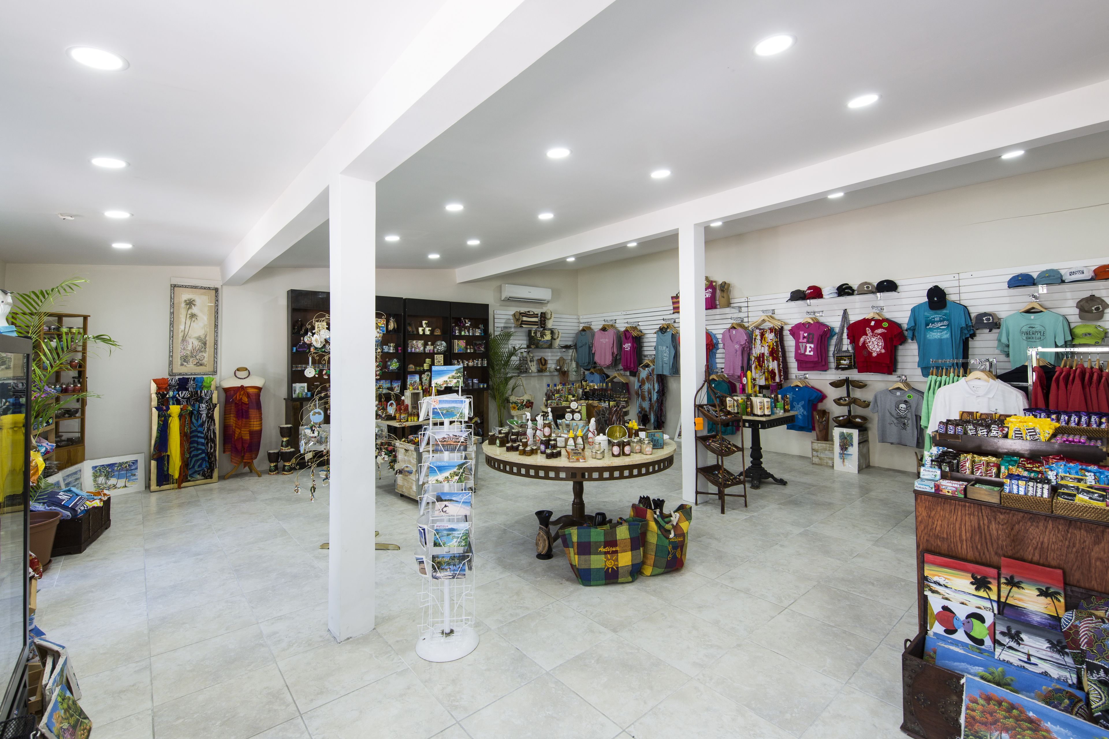 A spacious retail store with various clothing items and accessories displayed on racks and tables.