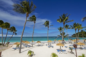 Am Strand, weißer Sandstrand, Liegestühle, Sonnenschirme