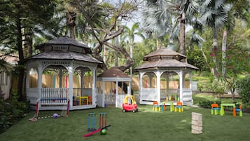 Children can play and relax under the gazebos with colorful play equipment and lush greenery.