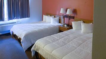 Habitació d'hotel amb dos llits, una nit diverses làmpades, una finestra amb cortines i un aparell d'aire condicionat.
