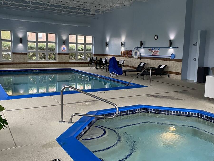 An indoor swimming pool with clear water, a blue edge, and a lifeguard station.