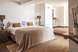 A bedroom with a large bed, two bedside tables, a nightstand, a dresser, and a potted orchid. - Surplage Hôtel Cavalière (Le Lavandou)