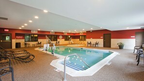 An indoor swimming pool with a lifeguard chair, a bench, and a potted plant. - Holiday Inn Express & Suites Chicago-Deerfield/Lincolnshire by IHG (Deerfield)