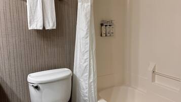 A bathroom with a toilet, a bathtub, and a shower curtain.