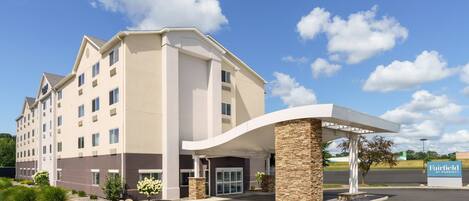 A multi-story hotel with a modern design, featuring a covered entrance and a sign indicating it is a Marriott property.
