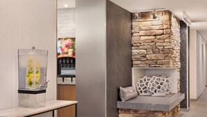 A modern interior with a stone accent wall, a clear glass display case, and a wooden reception desk.