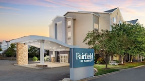 A Fairfield by Marriott hotel entrance with a covered walkway, stone pillar, and a signboard.