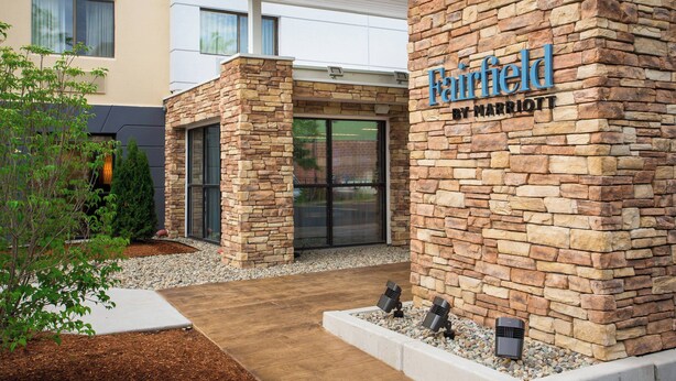 A Marriott hotel entrance with stone pillars, a glass door, and a sign. - Fairfield by Marriott Inn & Suites Raynham Middleborough/Plymouth (Middleborough)