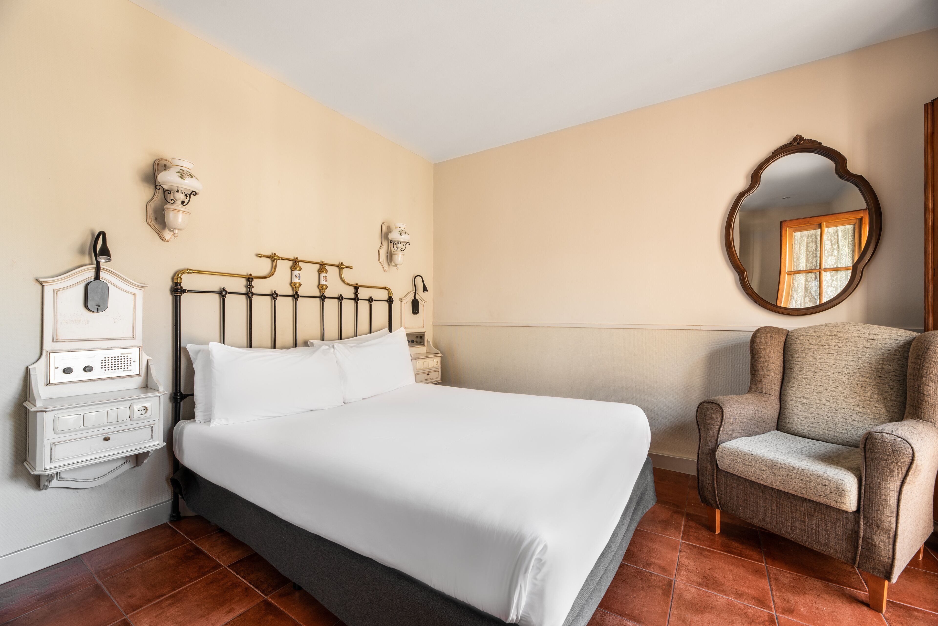 A neatly arranged bedroom with a bed, bedside table, lamp, and a chair.