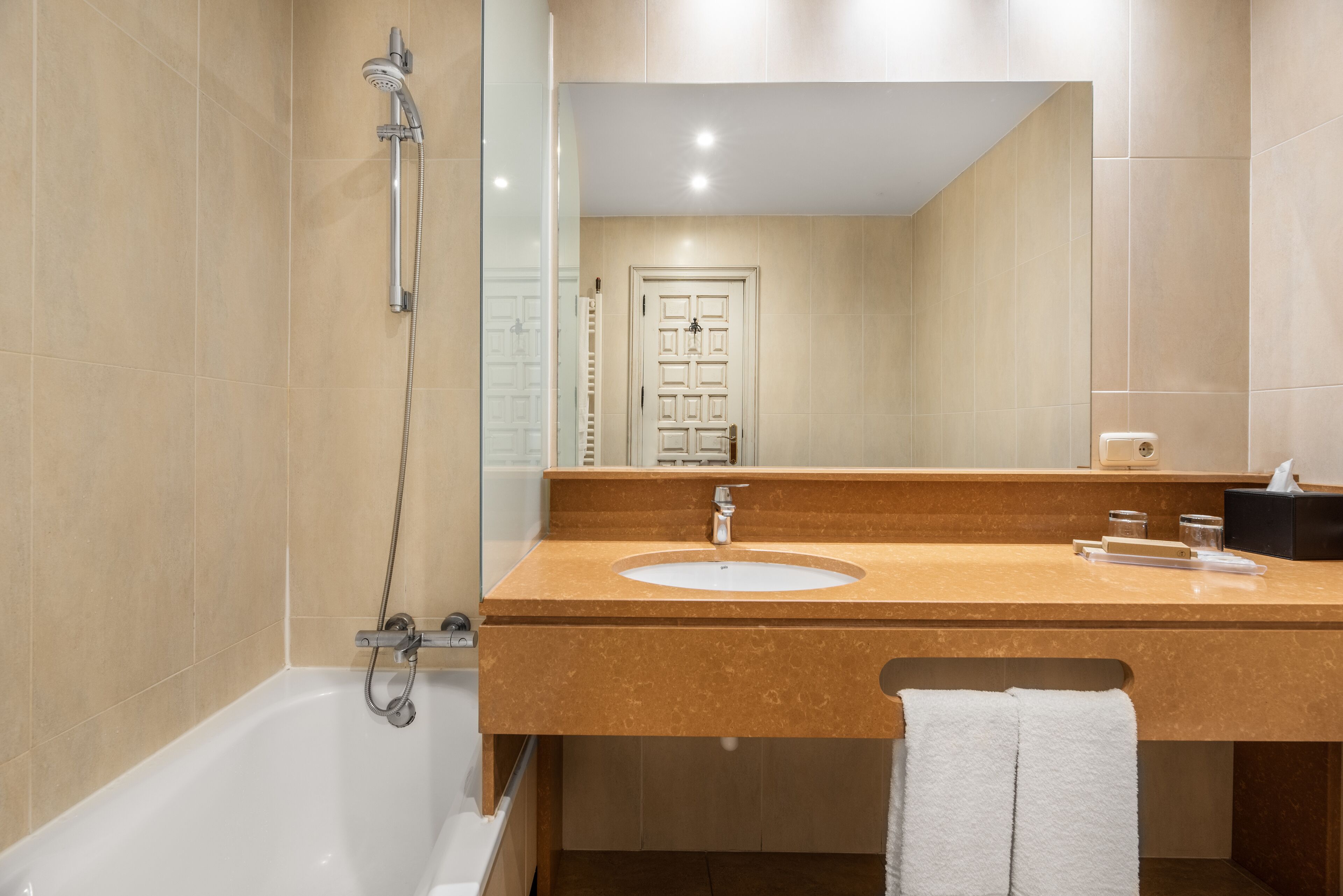 A modern bathroom with a bathtub, a sink, and a mirror.