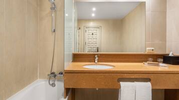 A modern bathroom with a bathtub, a sink, and a mirror.