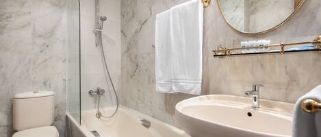 A bathroom with a toilet, a glass-enclosed shower, a bathtub, and a sink.