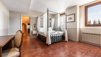 Un dormitorio con cama con dosel, un escritorio de madera y una silla.