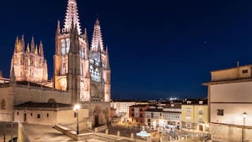A historic cathedral with twin spires, a courtyard, and surrounding buildings.