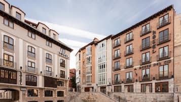 A hotel with multiple floors, balconies, and a central courtyard with a fountain.