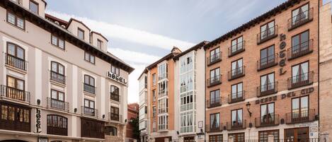 A hotel with multiple floors, balconies, and a central courtyard with a fountain.