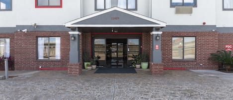 A building with a red-framed entrance, a number '12439' above the door, and a 'FDC' sign on the right side.