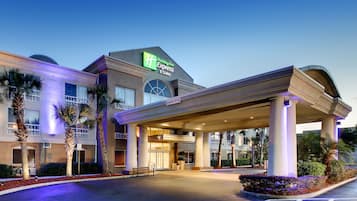 Welcome to the Holiday Inn Express & Suites, featuring a modern entrance with a covered walkway and large windows.