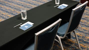 A conference table with name cards, pens, and glasses.