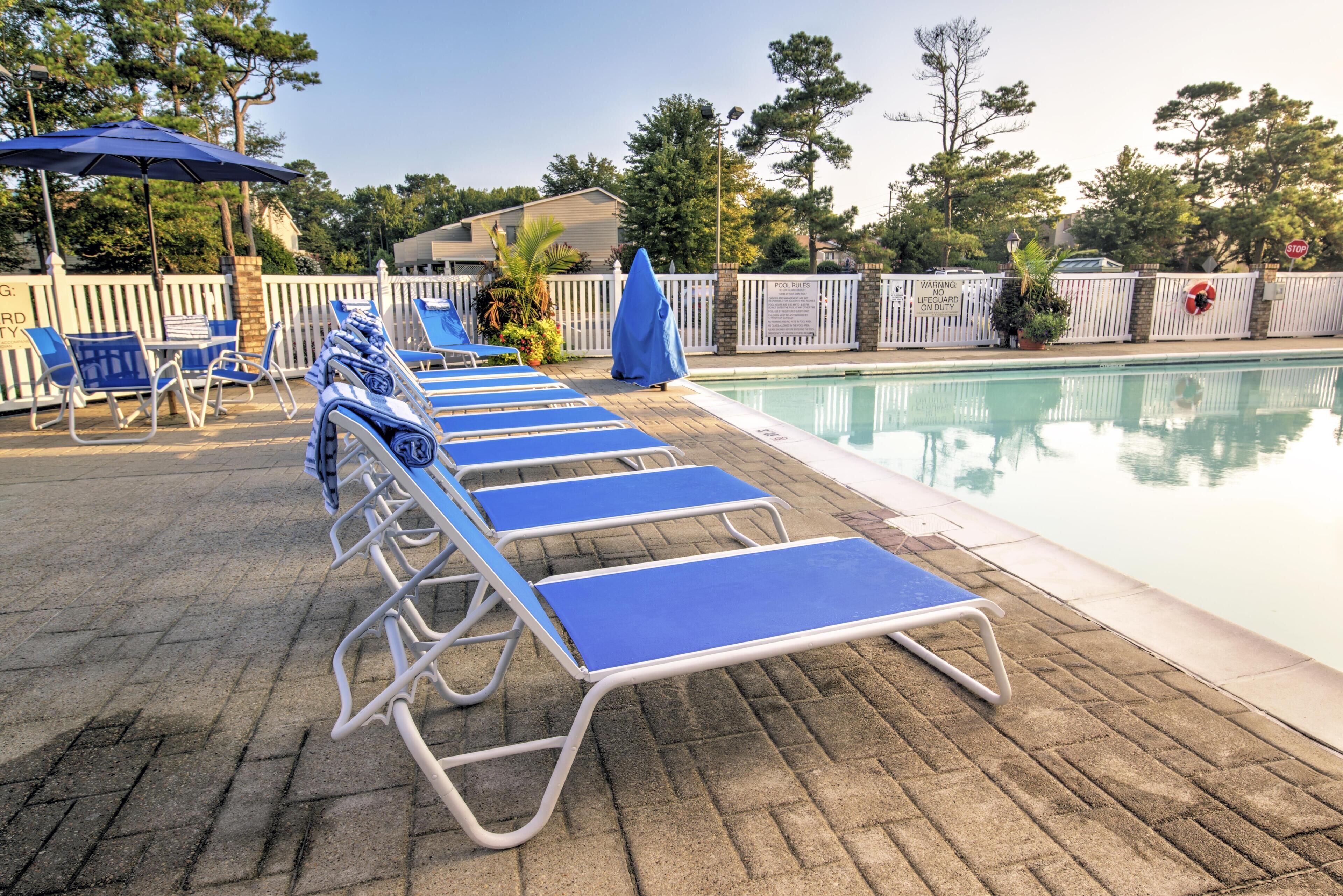 A poolside area with lounge chairs and umbrellas.