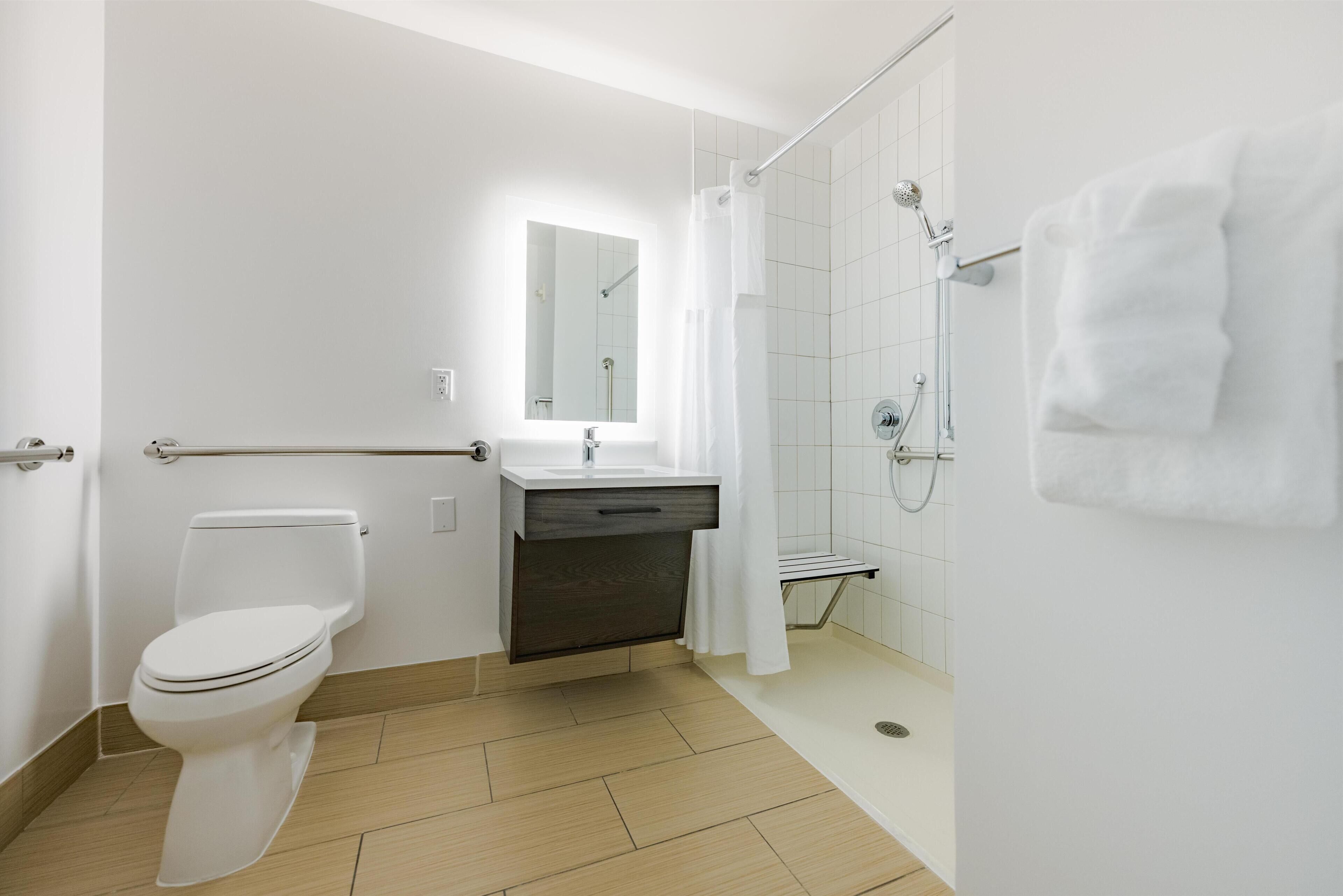 A modern bathroom with a toilet, sink, and shower.