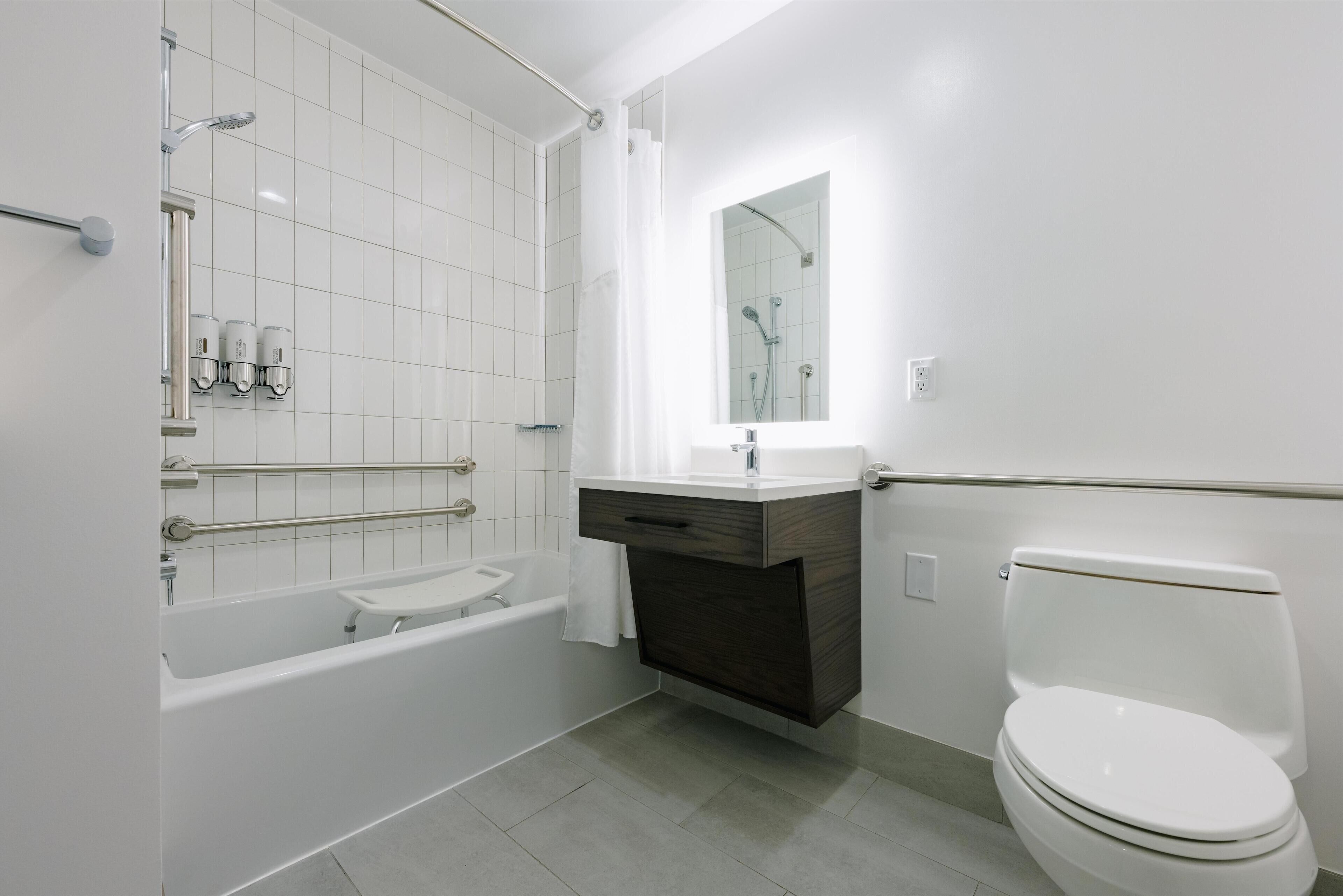 Un baño moderno con bañera, inodoro y tocador.