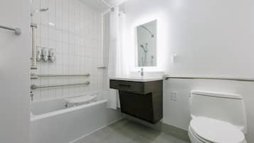 Un baño moderno con bañera, inodoro y tocador.