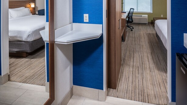 Une chambre d’hôtel avec un lit, un bureau, une chaise et une salle de bain.