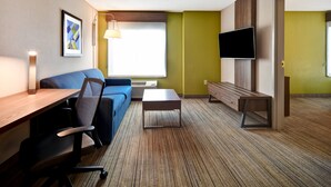 Une chambre d’hôtel moderne équipée d’un canapé, d’un bureau et d’une télévision.