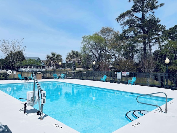 Una piscina al aire libre, tumbonas