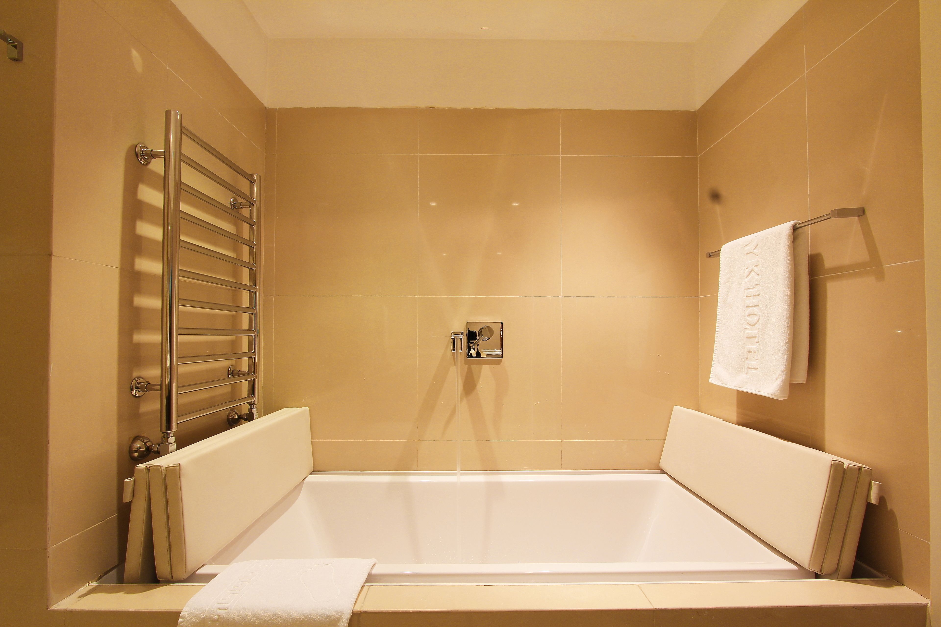 Une salle de bain moderne avec une baignoire, un porte-serviettes et un espace douche.