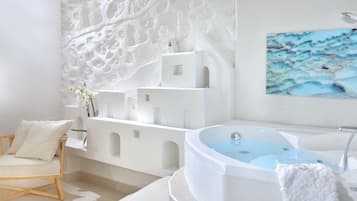 Bathroom features a bathtub, modern sink, and comfortable chair.