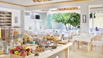 A breakfast buffet with various fruits, breads, and cereals.