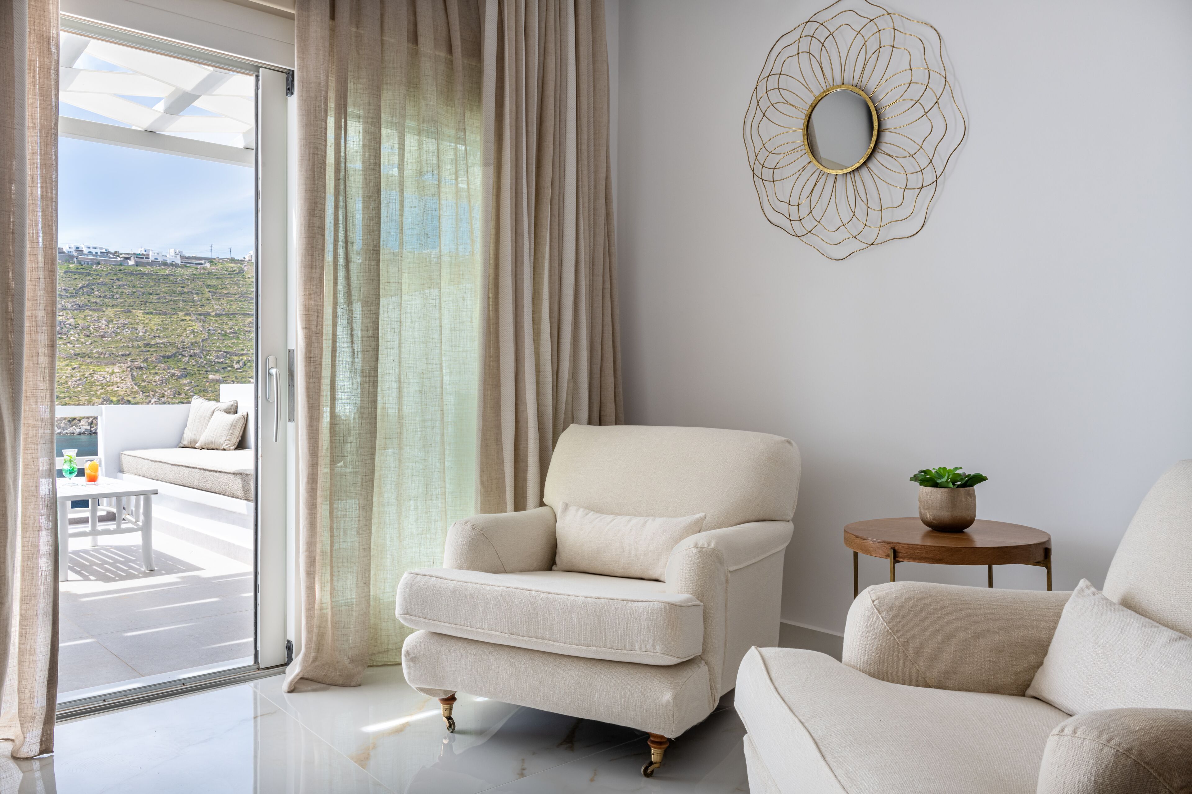 Una sala de estar moderna con un sofá, un sillón y una mesita con una planta.