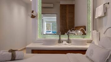 Un baño moderno con dos lavamanos, un espejo grande y vistas al exterior.