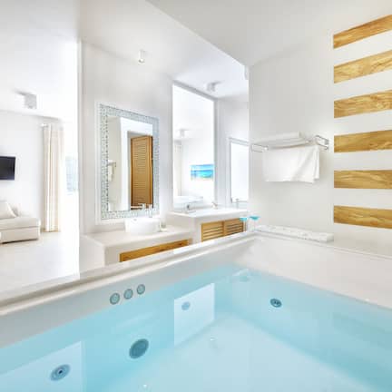 A modern bathroom with a bathtub, a sink, and a mirror.