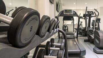 A gym with weightlifting equipment, treadmills, and exercise machines.