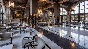 A spacious lobby with modern furniture, large windows, and elegant chandeliers. - Lopesan Costa Meloneras Resort & Spa   (San Bartolomé de Tirajana)