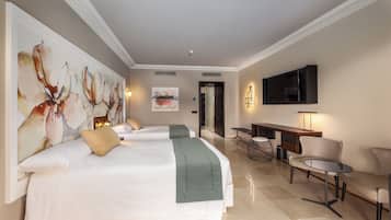 Una habitación de hotel con una cama grande, un escritorio, una silla y un televisor fijado a la pared.