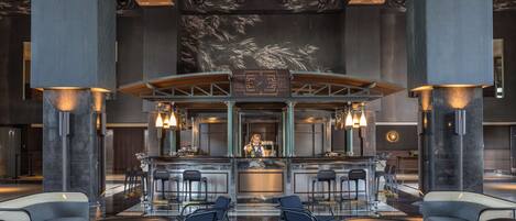A modern bar area with a central counter, bar stools, and seating arrangements.