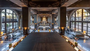 A spacious hotel lobby with a central seating area, large windows, and a chandelier. - Lopesan Costa Meloneras Resort & Spa   (San Bartolomé de Tirajana)