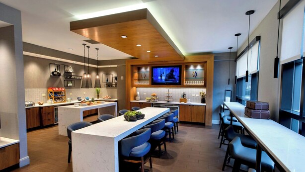 Een moderne keuken met een centraal eiland, een bar en een televisie.